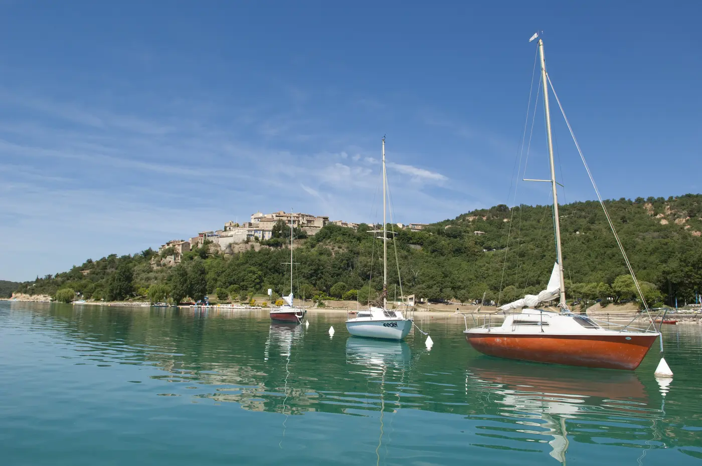 Voiliers sur les eaux turquoise du lac de Sainte-Croix devant le village perché, Gorges du Verdon