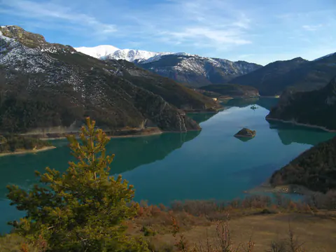 Der türkisfarbene Lac de Castillon, im Februar von Blaron aus gesehen, mit verschneiten Gipfeln im Hintergrund