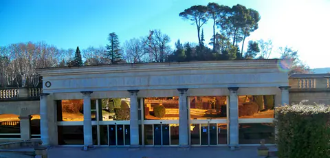 Der Säulengang am Eingang der Thermen von Gréoux-les-Bains in der Februarsonne, mit Schirmkiefern